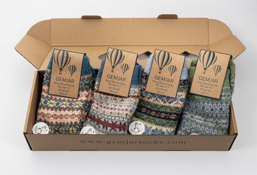 Box of GemJar socks with colorful patterns and brand tags on a white background