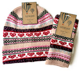 A knit beanie and matching glove set from Gemjar, featuring a Fair Isle pattern with red hearts, black and pink stripes, and light blue accents on a cream base. Both items are shown with their original kraft paper tags.