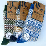 Three pairs of Gemjar soft cozy socks with open-knit patterns, displayed on brown paper packaging cards. The socks are shown in three colorways: dark green with brown, blue and cream, and blue and cream.